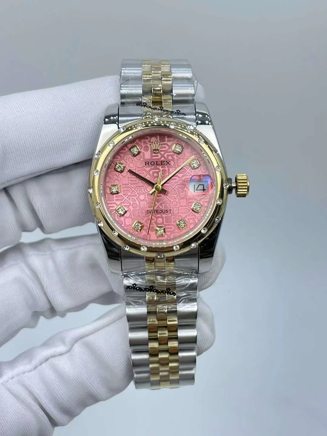 Two tone gold luxury watch bezel showing detailed crystal decoration accents