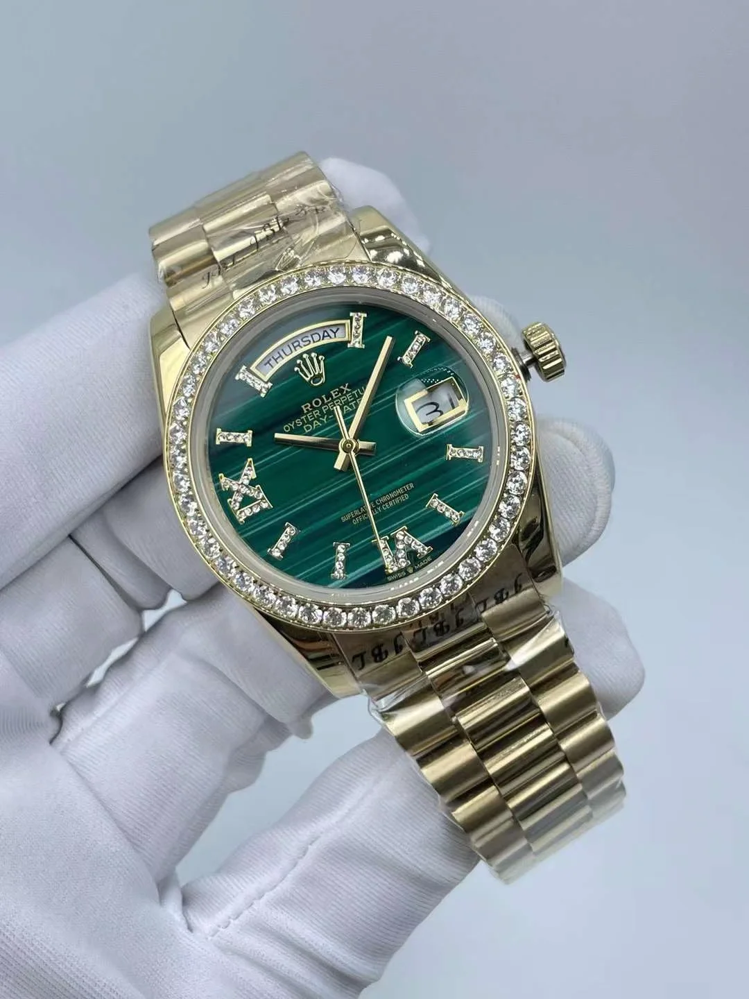 Close up detail of yellow gold casing and luxury green dial
