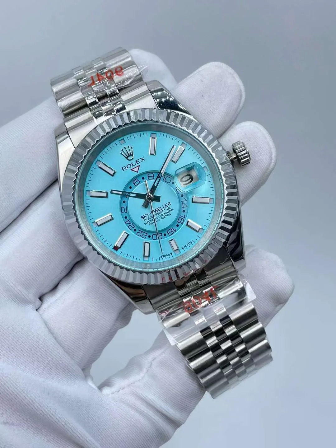 Close up shot of the luminous hands and markers on turquoise watch dial