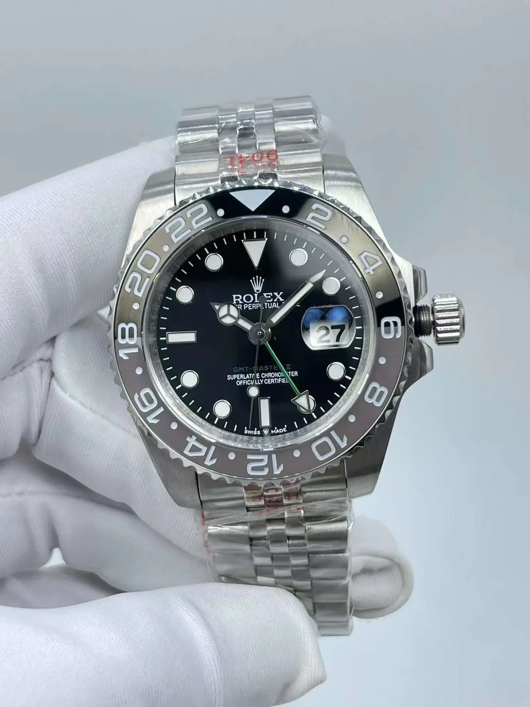 Luxury black dial with luminescent hour markers and green GMT hand